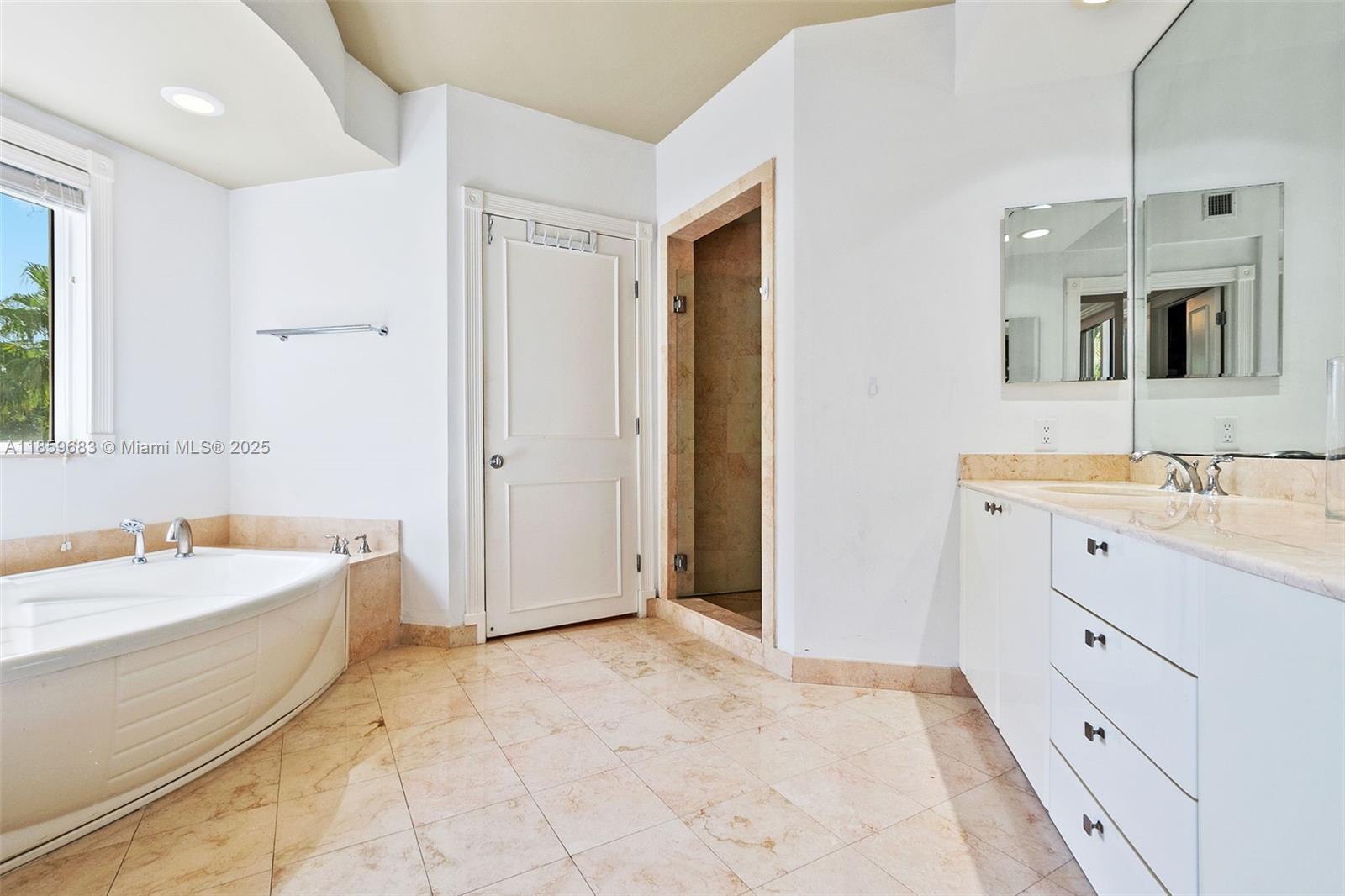 781 Crandon Boulevard, Unit 306 Key Biscayne, FL 33149 - Photo 17 of 32 a bathroom with a tub sink and mirror
