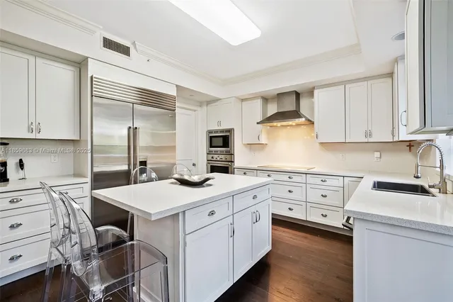 a kitchen with granite countertop a stove sink and refrigerator