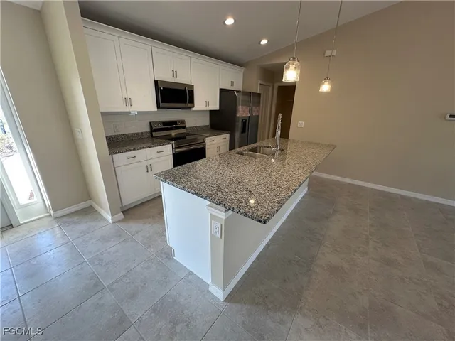 a kitchen with a sink a microwave a stove and refrigerator