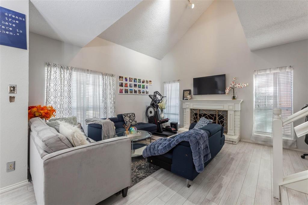 4050 Frankford Road, Unit 908 Dallas, TX 75287 - Photo 9 of 16 Spacious living area featuring a vaulted ceiling and wood-finish flooring