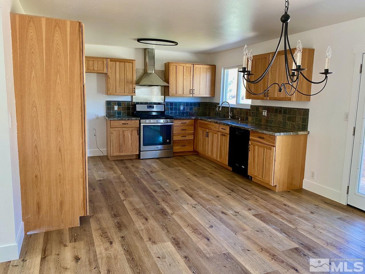 10775 Osage Road Reno, NV 89508 - Photo 3 of 22 a kitchen with stainless steel appliances granite countertop a stove a sink dishwasher and a refrigerator with wooden floor