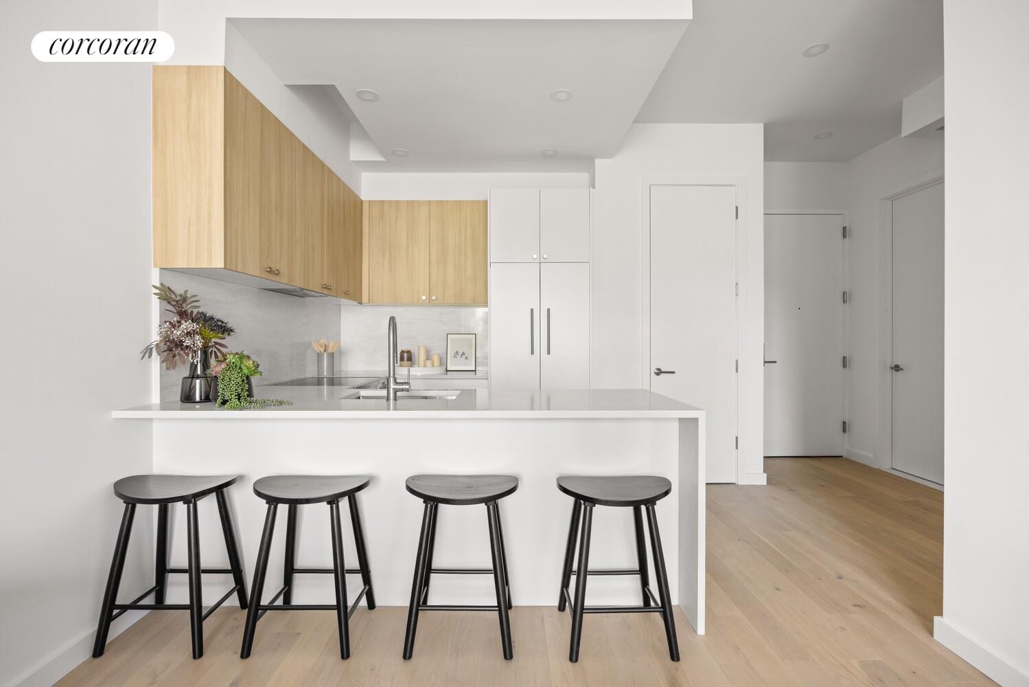 a kitchen with stainless steel appliances kitchen island a table chairs in it and white cabinets