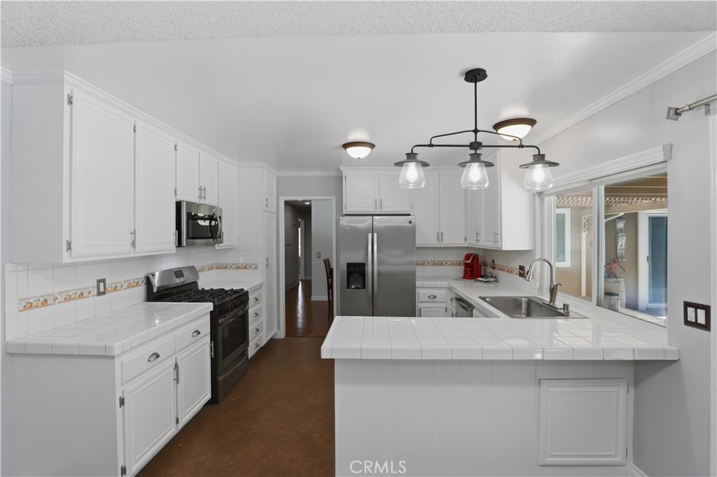 1340 Cadwell Court Riverside, CA 92506 - Photo 19 of 63 a kitchen with stainless steel appliances kitchen island a sink stove and refrigerator