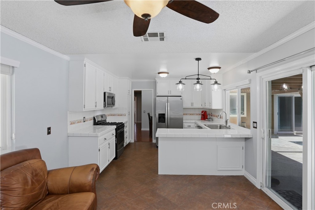 1340 Cadwell Court Riverside, CA 92506 - Photo 22 of 63 a living room with stainless steel appliances kitchen island furniture and a chandelier