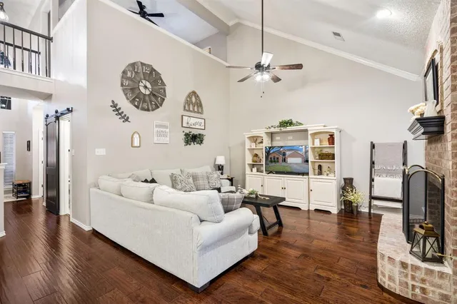 a living room with furniture a clock and a flat screen tv