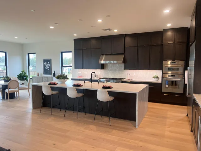 a kitchen with kitchen island granite countertop a sink and a stove