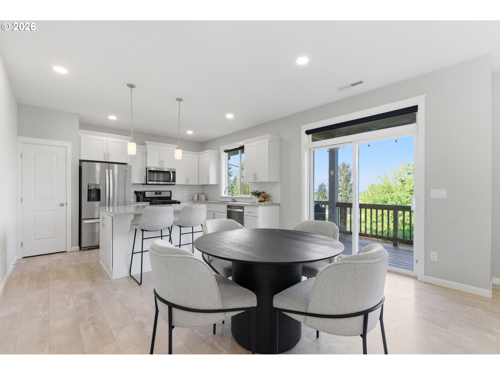 33068 Northwest Ej Smith Road Scappoose, OR 97056 - Photo 15 of 43 a kitchen with stainless steel appliances kitchen island granite countertop a dining table chairs and a refrigerator