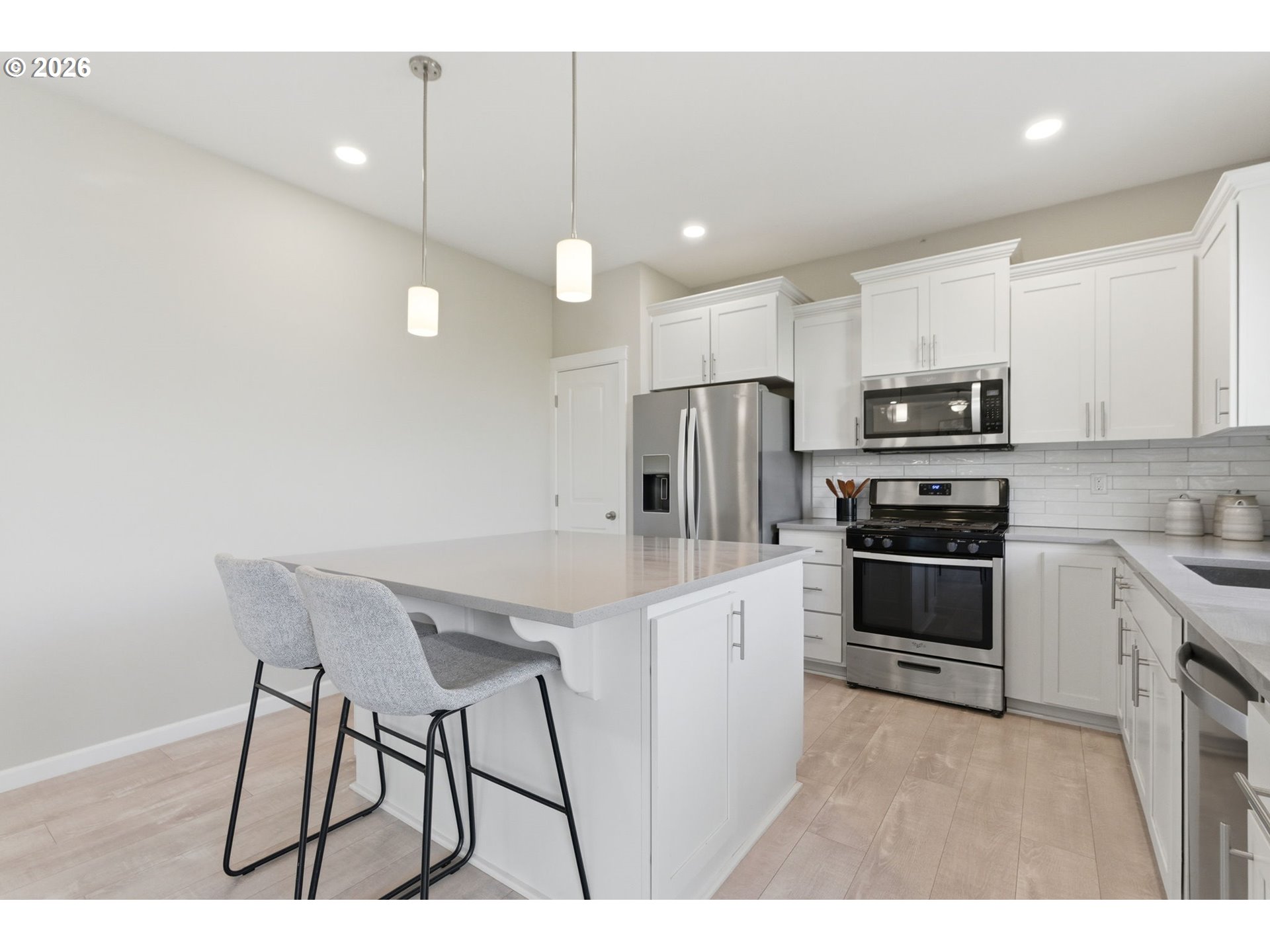 33068 Northwest Ej Smith Road Scappoose, OR 97056 - Photo 17 of 43 a kitchen with kitchen island white cabinets and stainless steel appliances