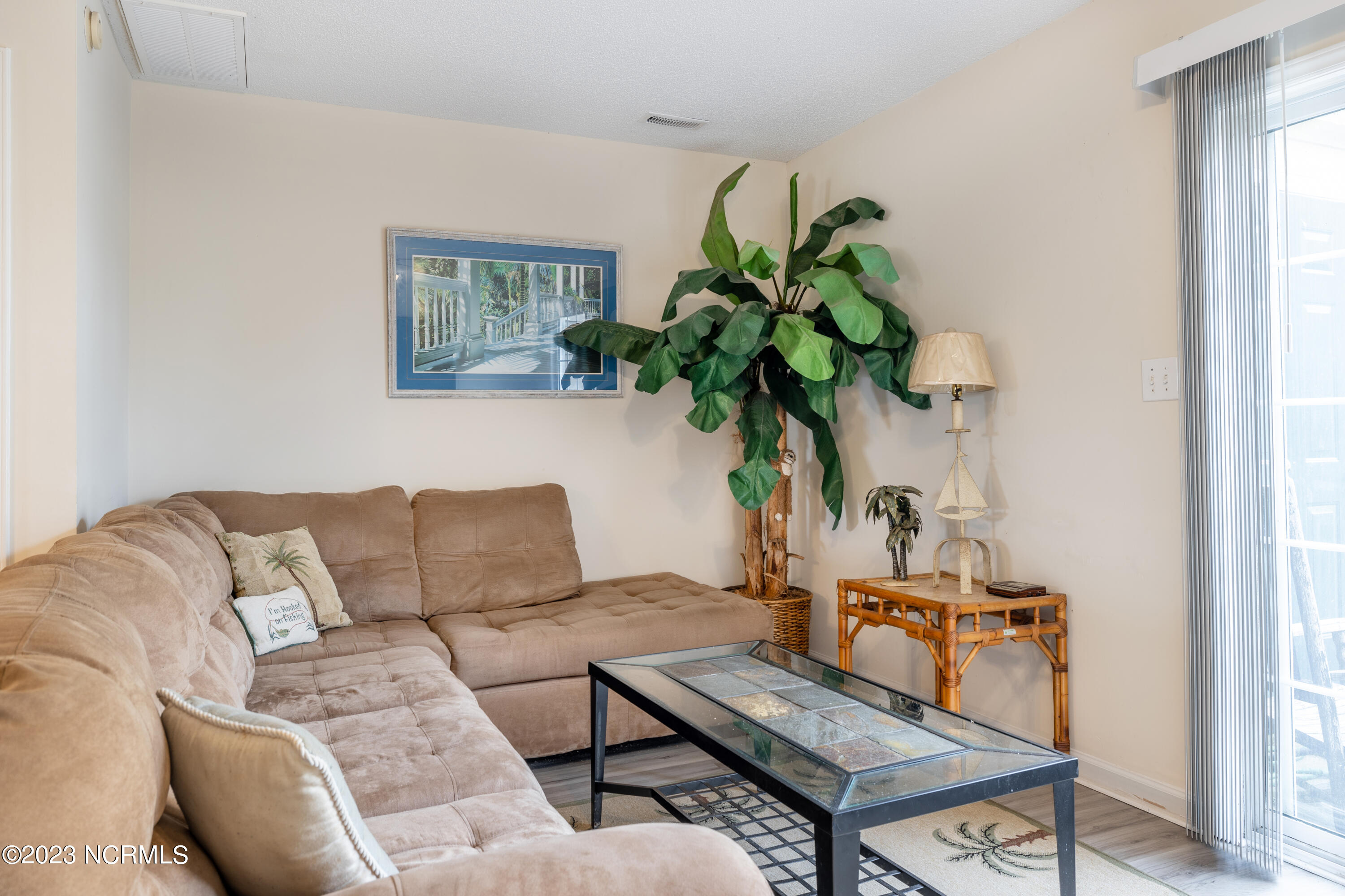 601 Peletier Loop Road, Unit E27 Swansboro, NC 28584 - Photo 7 of 17 Living Room View with Sliding Door to Exterior Patio and Storage Room