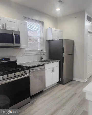 a kitchen with a refrigerator stove and wooden cabinets