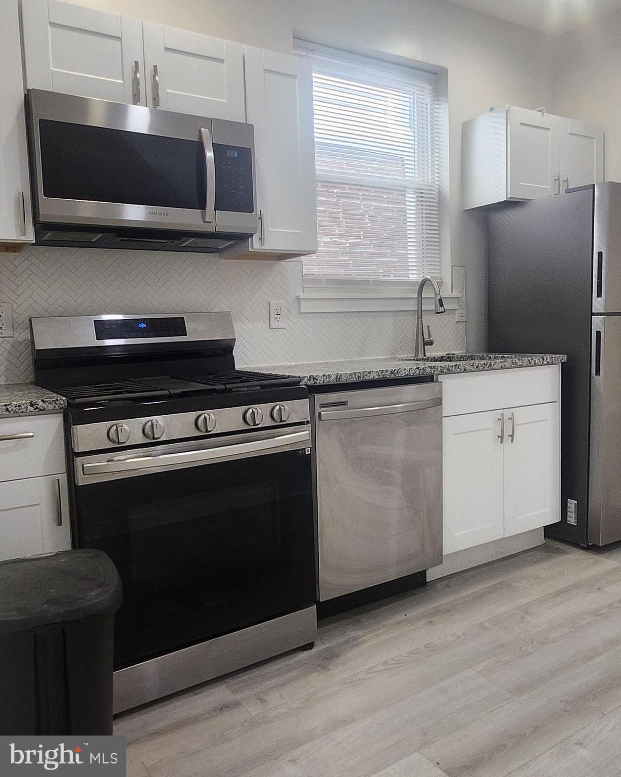 2230 Christian Street, Unit 3 Philadelphia, PA 19146 - Photo 3 of 16 a kitchen with stainless steel appliances a stove a sink and a microwave
