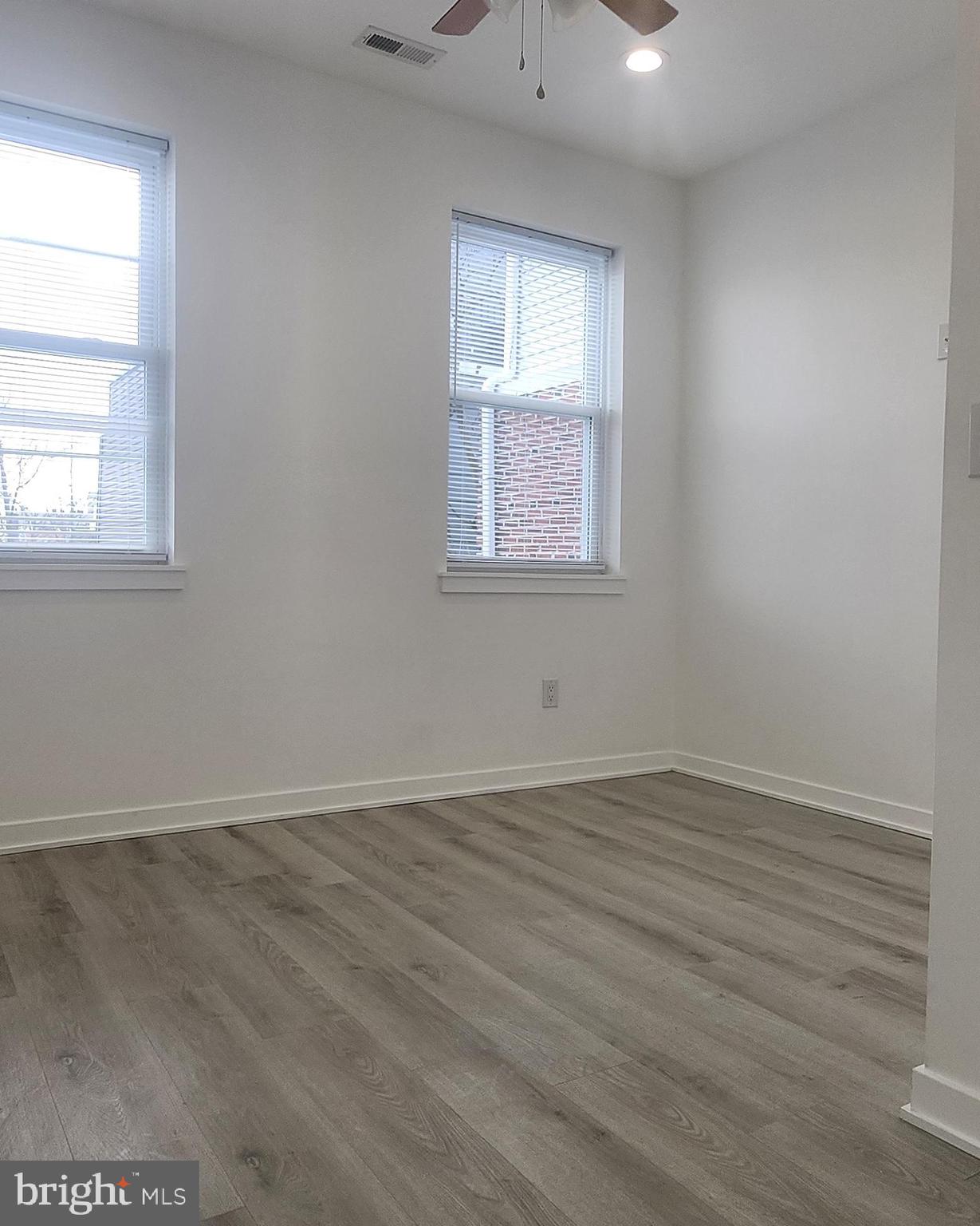 2230 Christian Street, Unit 3 Philadelphia, PA 19146 - Photo 9 of 16 an empty room with wooden floor and windows