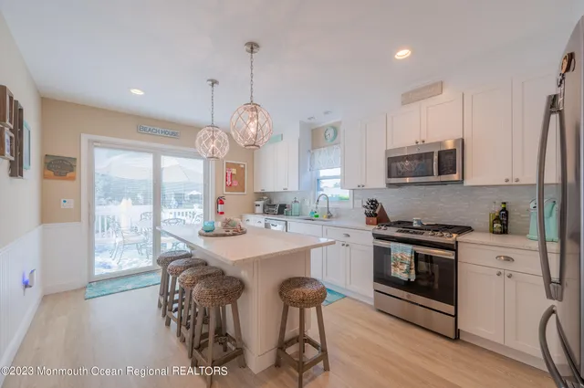 a kitchen with stainless steel appliances a stove a sink a microwave a refrigerator and cabinets