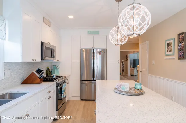 a kitchen with stainless steel appliances granite countertop a sink and refrigerator