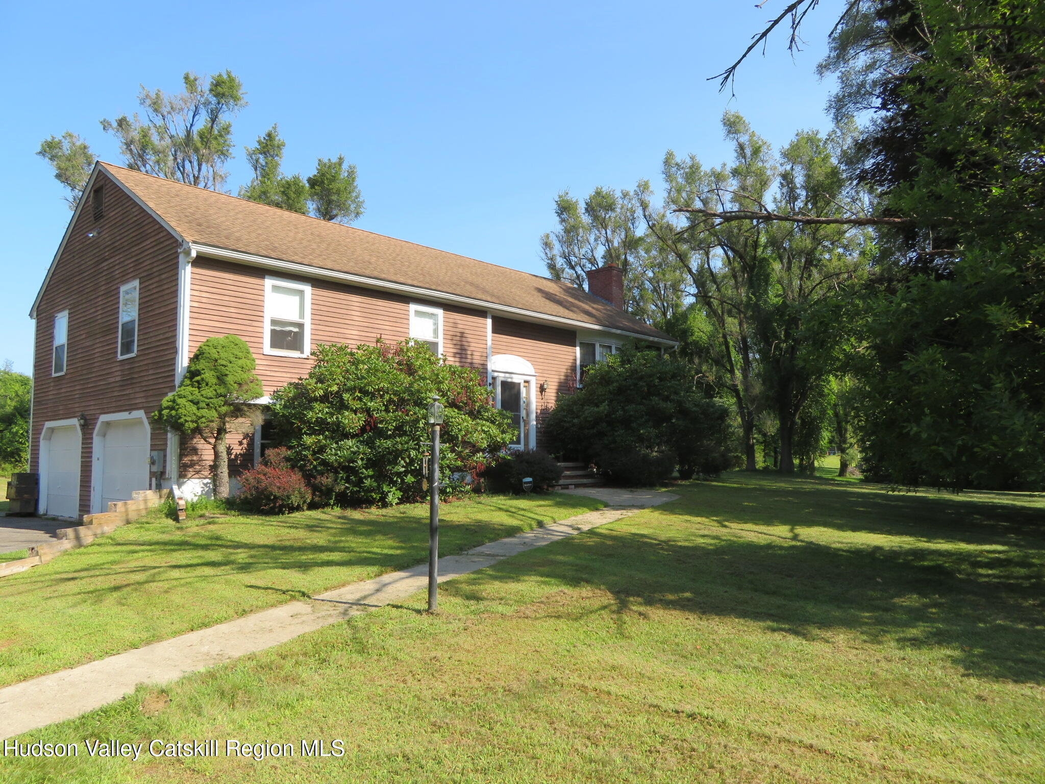 a view of a house with a big yard and potted plants