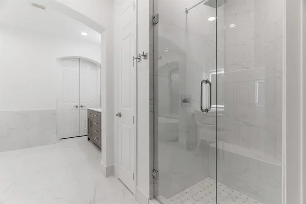 a bathroom with a shower and a glass door
