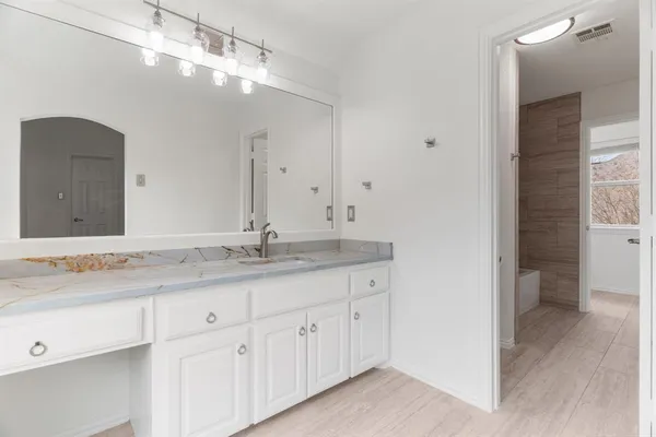 a bathroom with a granite countertop sink and a mirror