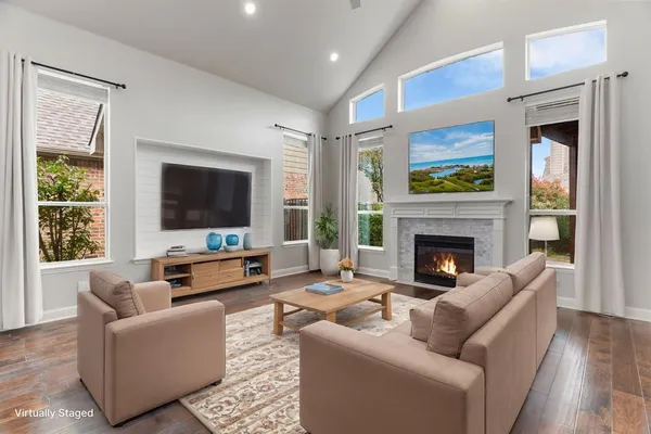 a living room with furniture a flat screen tv and a fireplace