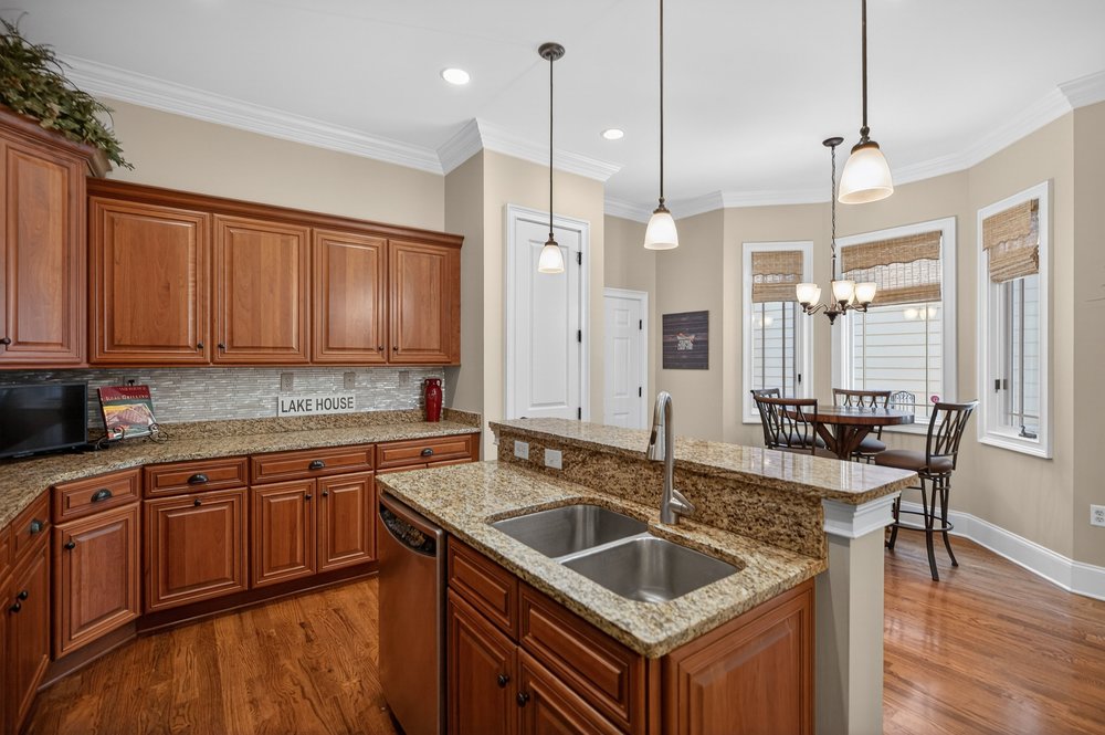 132 Regatta Drive Anderson, SC 29625 - Photo 18 of 50 This kitchen features rich wood cabinetry, granite countertops, and hardwood flooring.