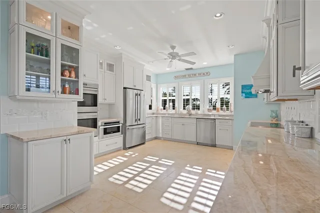 a kitchen with stainless steel appliances kitchen island granite countertop a refrigerator and cabinets