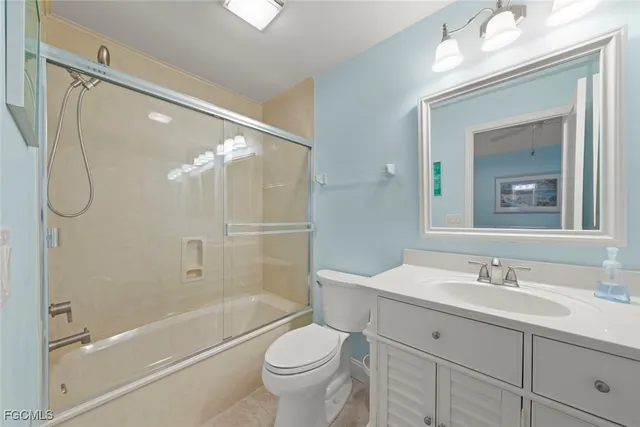 a bathroom with a double vanity sink toilet mirror and shower