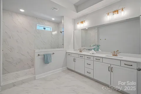 a spacious bathroom with double sink and mirror