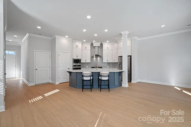 a view of kitchen with kitchen island dining table and wooden floor