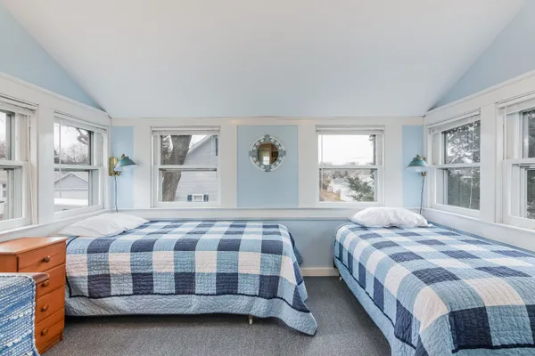 a bedroom with two beds and large windows