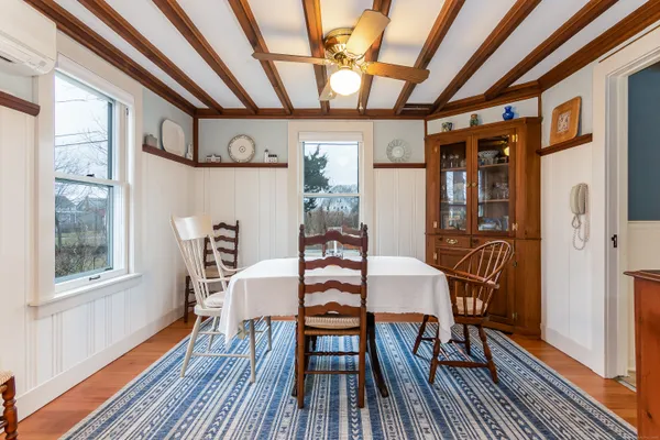 a dining room with furniture a chandelier and wooden floor