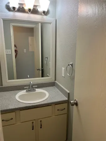 a bathroom with a granite countertop toilet and a sink