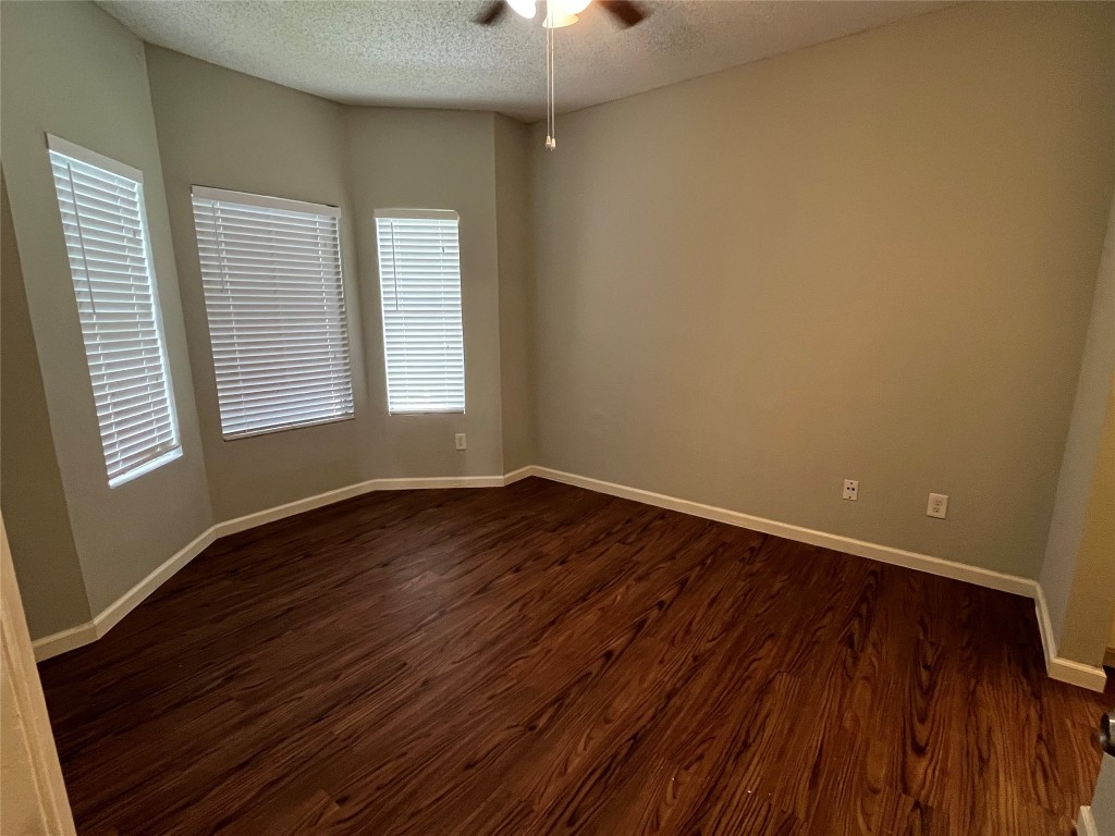 9502 Kempler Drive, Unit B Austin, TX 78748 - Photo 5 of 18 Empty room with a ceiling fan, a textured ceiling, and dark wood-style flooring