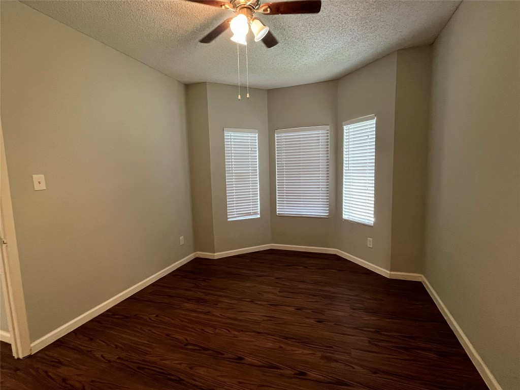 9502 Kempler Drive, Unit B Austin, TX 78748 - Photo 10 of 18 Spare room with a textured ceiling, dark wood-style flooring, and a ceiling fan