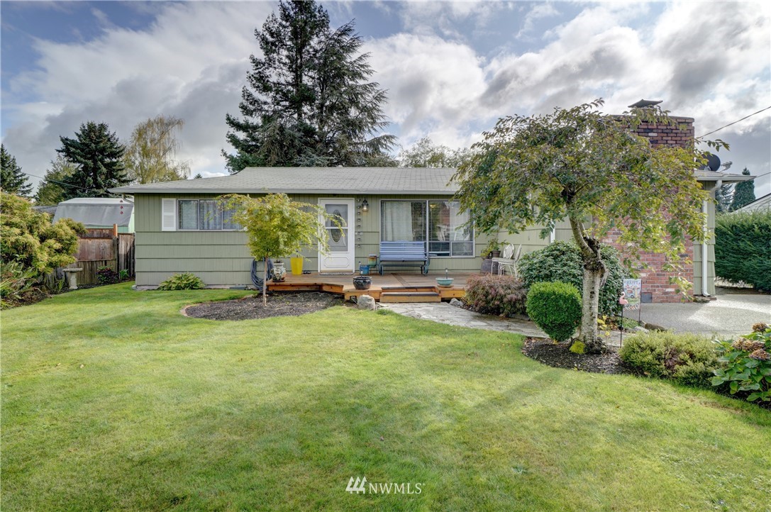 a view of a house with backyard and sitting area