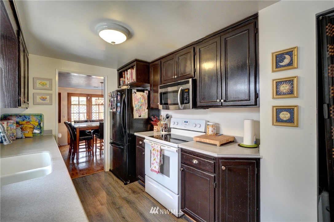 16116 119th Avenue Southeast Renton, WA 98058 - Photo 8 of 20 a kitchen with stainless steel appliances granite countertop a refrigerator and wooden cabinets