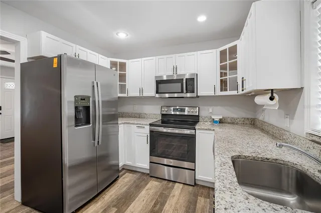 a kitchen with stainless steel appliances granite countertop a refrigerator stove and microwave