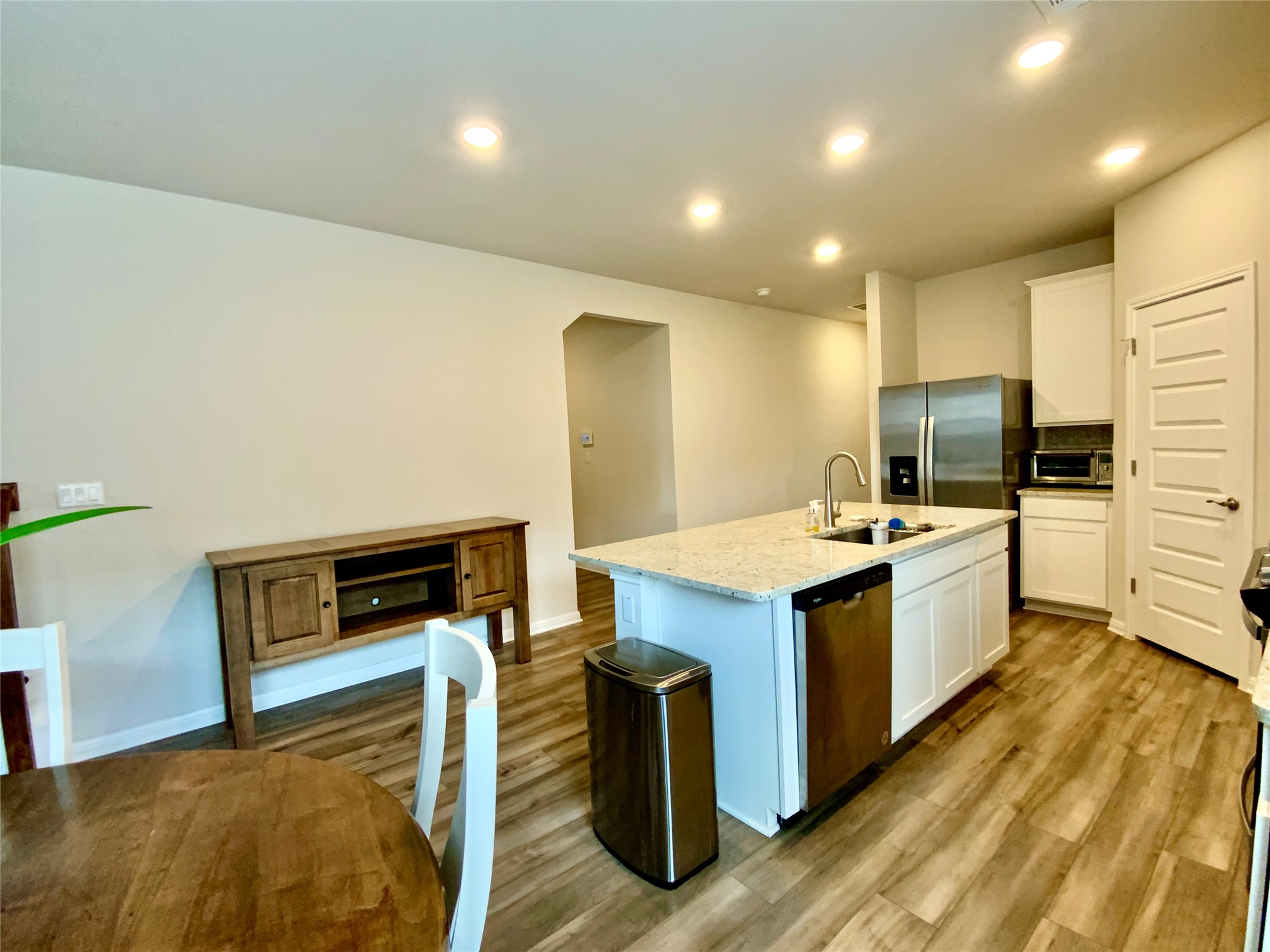 246 El Capitan Loop Dripping Springs, TX 78620 - Photo 11 of 37 Kitchen with white cabinets, light wood-style floors, an island with sink, and recessed lighting