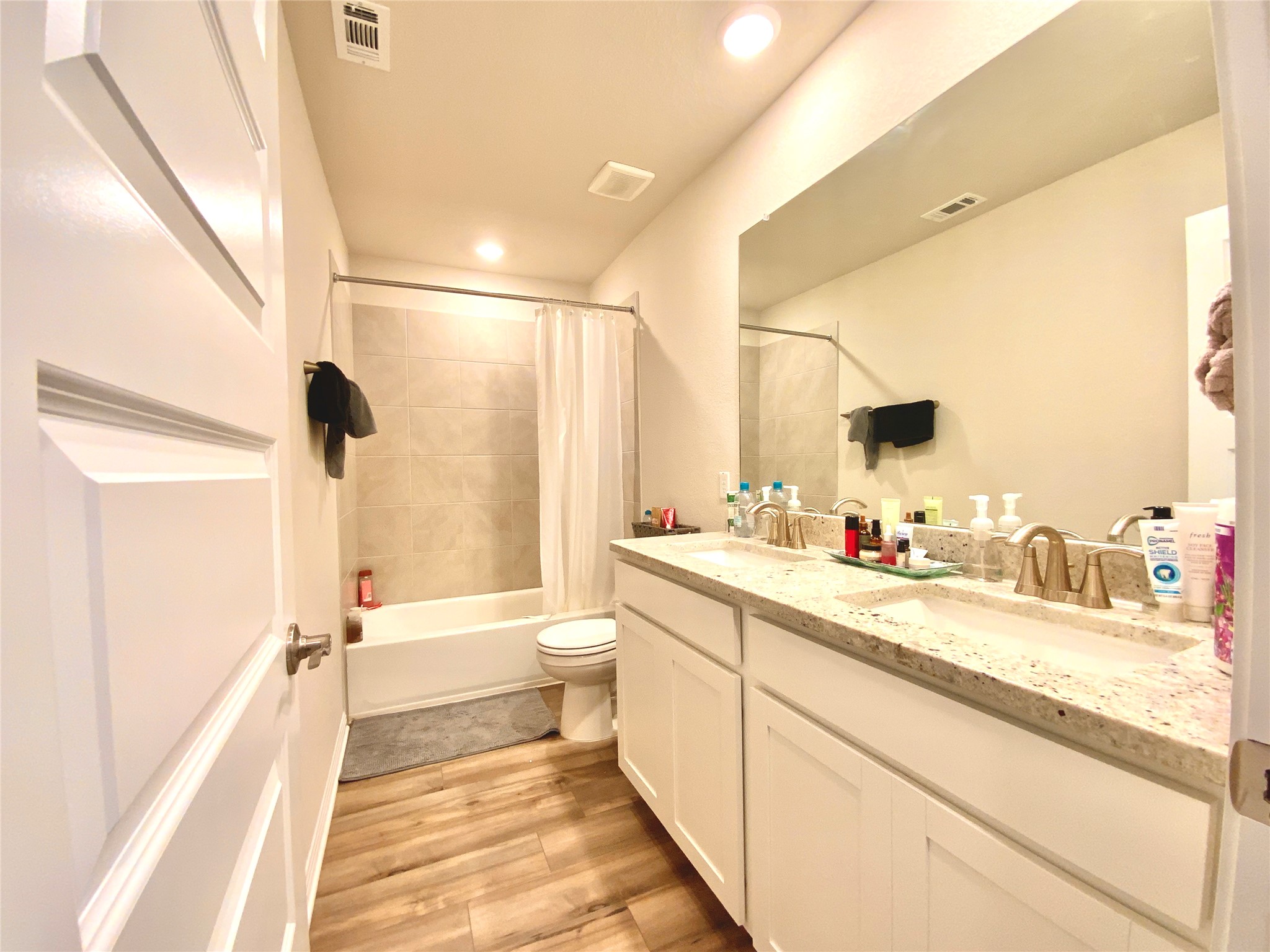 246 El Capitan Loop Dripping Springs, TX 78620 - Photo 29 of 37 Full bathroom featuring double vanity, shower / tub combo, light wood-style floors, and recessed lighting