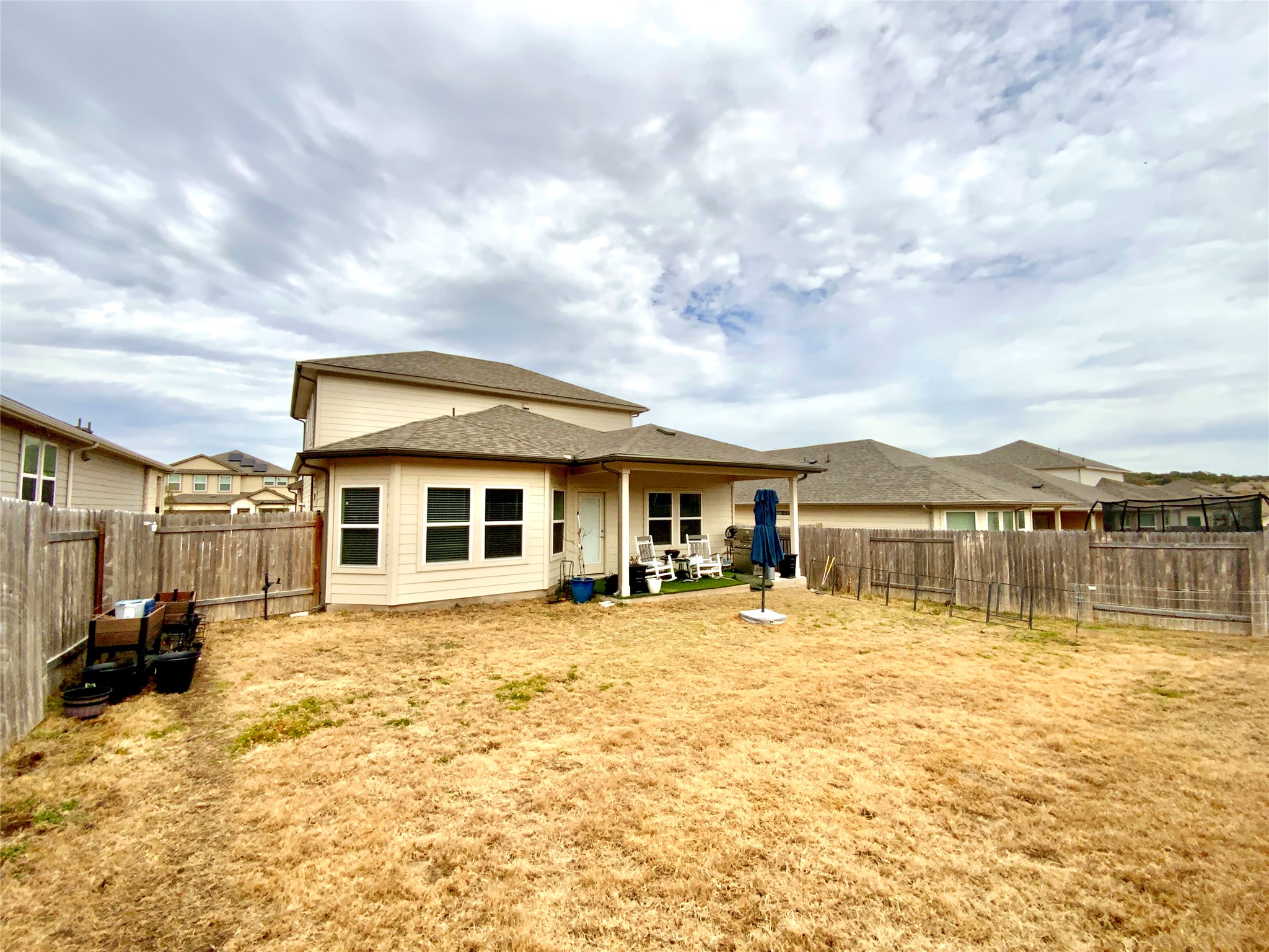 246 El Capitan Loop Dripping Springs, TX 78620 - Photo 33 of 37 Back of property featuring a patio area, a fenced backyard, and a shingled roof