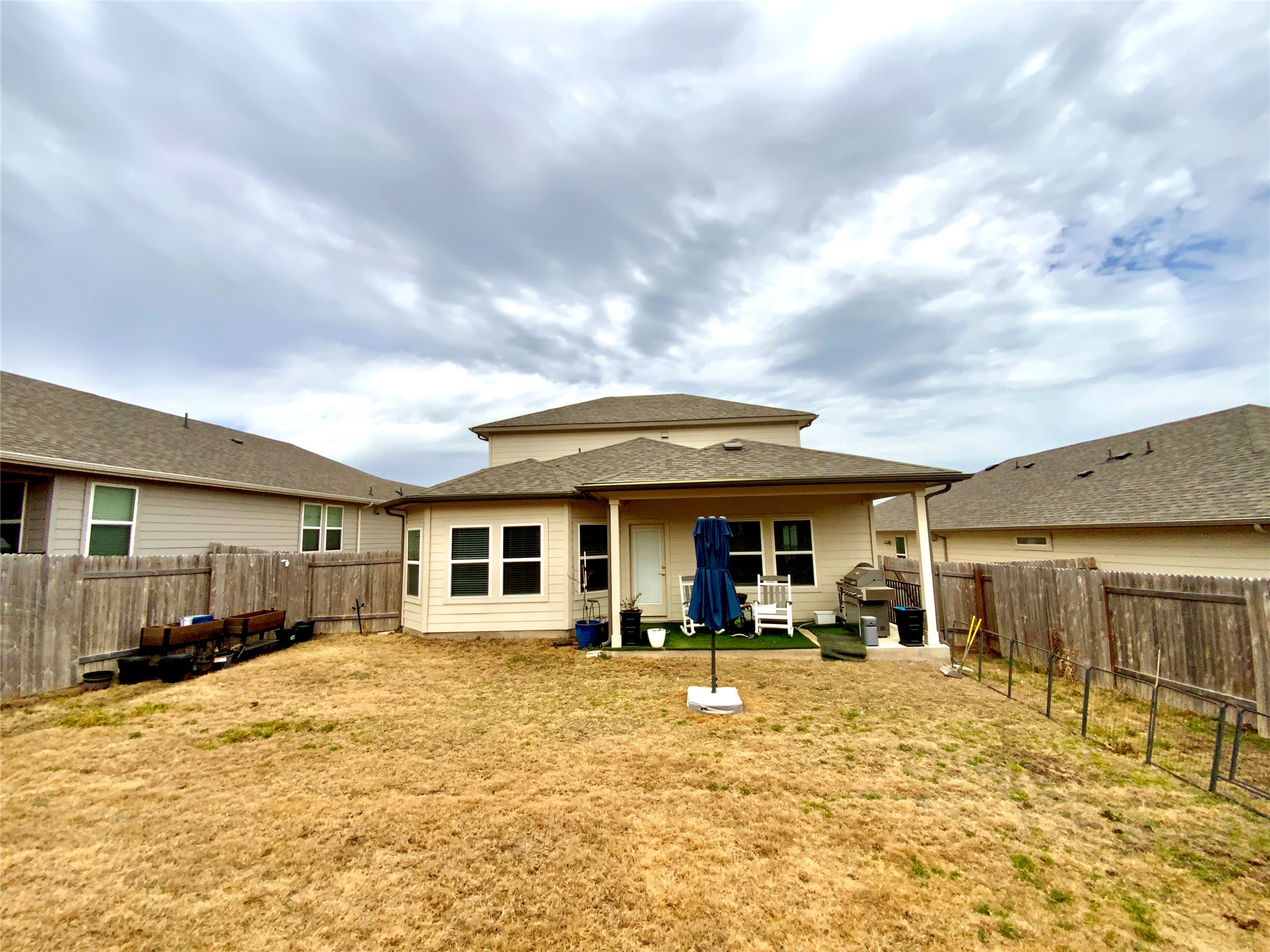 246 El Capitan Loop Dripping Springs, TX 78620 - Photo 34 of 37 Back of house featuring a patio, a fenced backyard, and roof with shingles