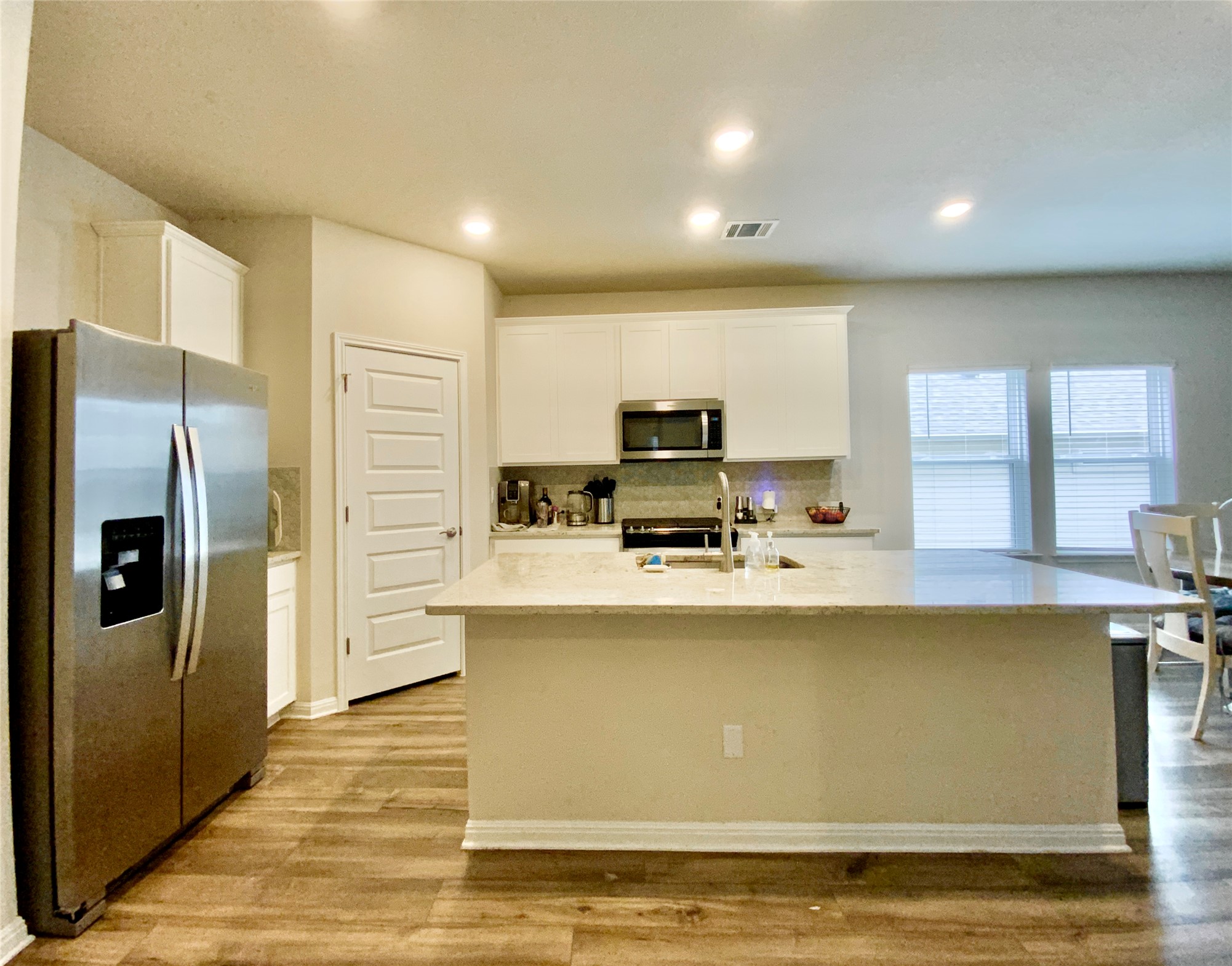 246 El Capitan Loop Dripping Springs, TX 78620 - Photo 9 of 37 Kitchen featuring stainless steel appliances, white cabinetry, a center island with sink, decorative backsplash, and recessed lighting