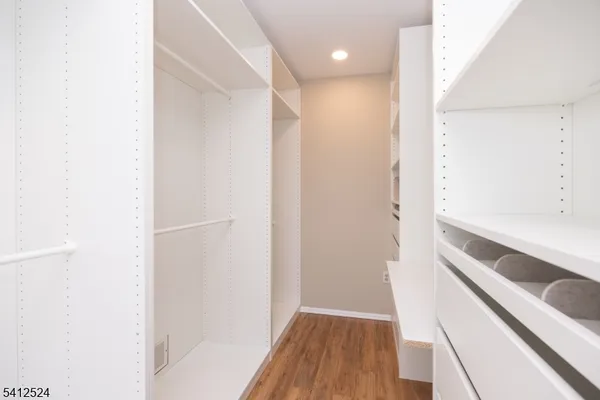 a view of walk in closet with wooden floor