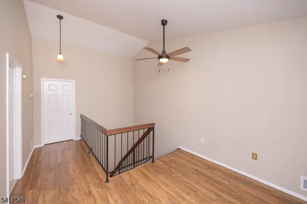 a view of a hallway with wooden floor and a chandelier