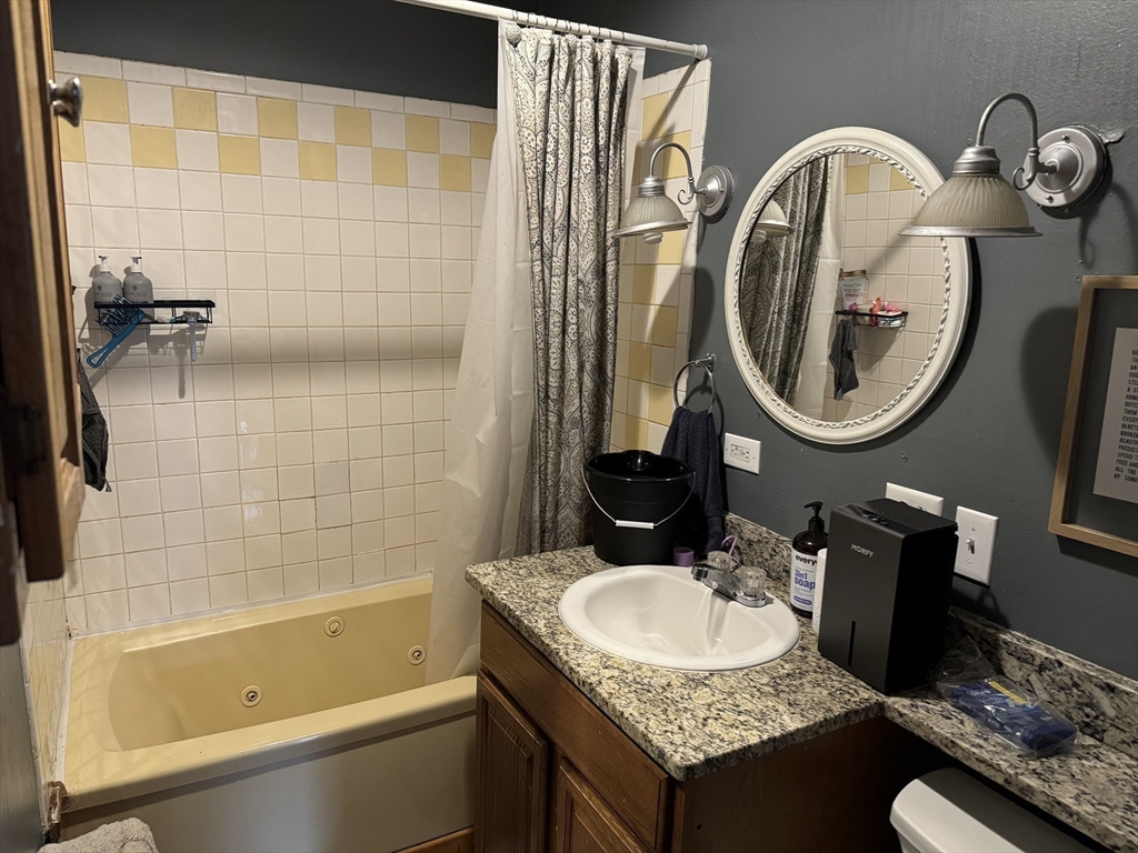 8 Eureka Street Worcester, MA 01603 - Photo 13 of 25 a bathroom with a granite countertop sink and a mirror