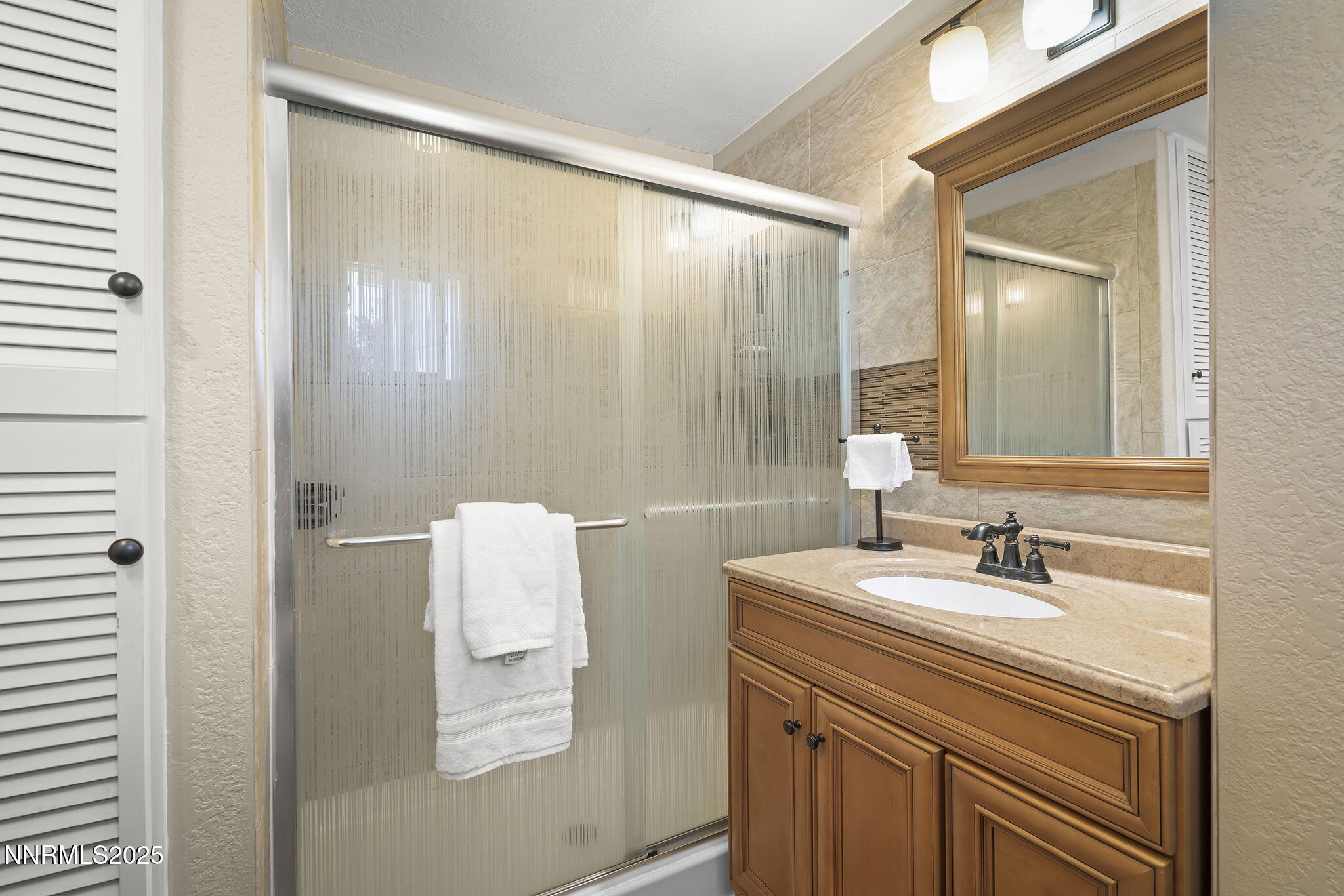 2195 West Plumb Lane Reno, NV 89509 - Photo 15 of 27 a bathroom with a sink and a mirror