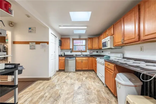 a kitchen with stainless steel appliances granite countertop a stove a sink dishwasher and a refrigerator