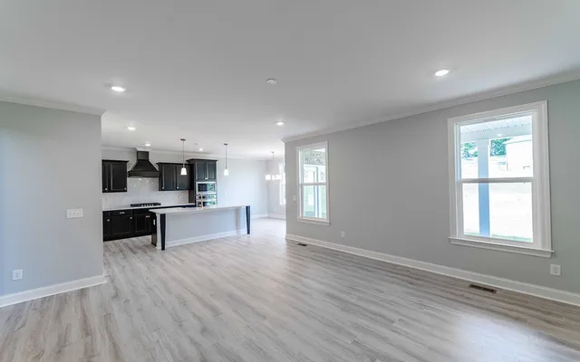 a large white kitchen with a large window and stainless steel appliances