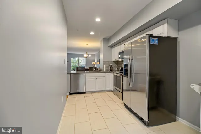 a kitchen with stainless steel appliances a refrigerator sink and cabinets