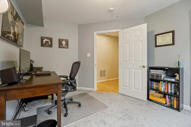a view of a workspace with furniture and a window