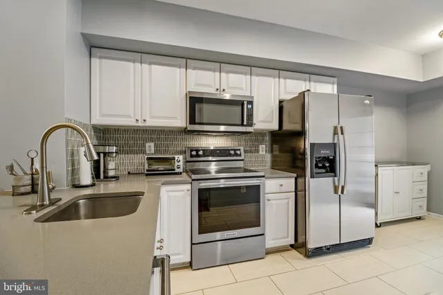 a kitchen with stainless steel appliances a stove a sink a microwave and cabinets