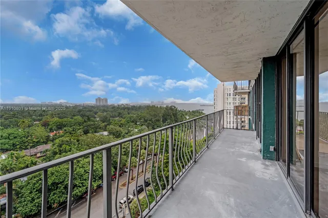 a dining hall with stainless steel appliances granite countertop a stove and a white cabinets